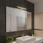 Kinkiet Klimt L40 LED 8W CCT IP44 w kolorze złotym, zamontowany nad lustrem w nowoczesnej łazience. Oświetlenie w kształcie prostokąta, z metalowym wykończeniem, na tle ciemnej, marmurowej ściany.