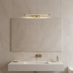 Kinkiet Klimt L60 LED 12W CCT IP44 w kolorze złotym, zamontowany na ścianie nad umywalką. Prostokątny kształt, z delikatnym podświetleniem, na tle jasnych płytek. Idealny do łazienki, podkreślający nowoczesny styl.