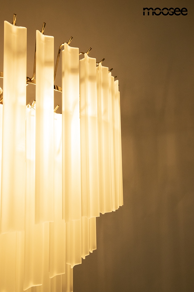 Lampa wisząca Gordon 80 z 21 punktami E14, złota, z przezroczystymi, prostokątnymi kloszami. Ujęcie z boku, ukazujące detale kloszy i ich fakturę. Tło neutralne, podkreślające elegancję lampy.