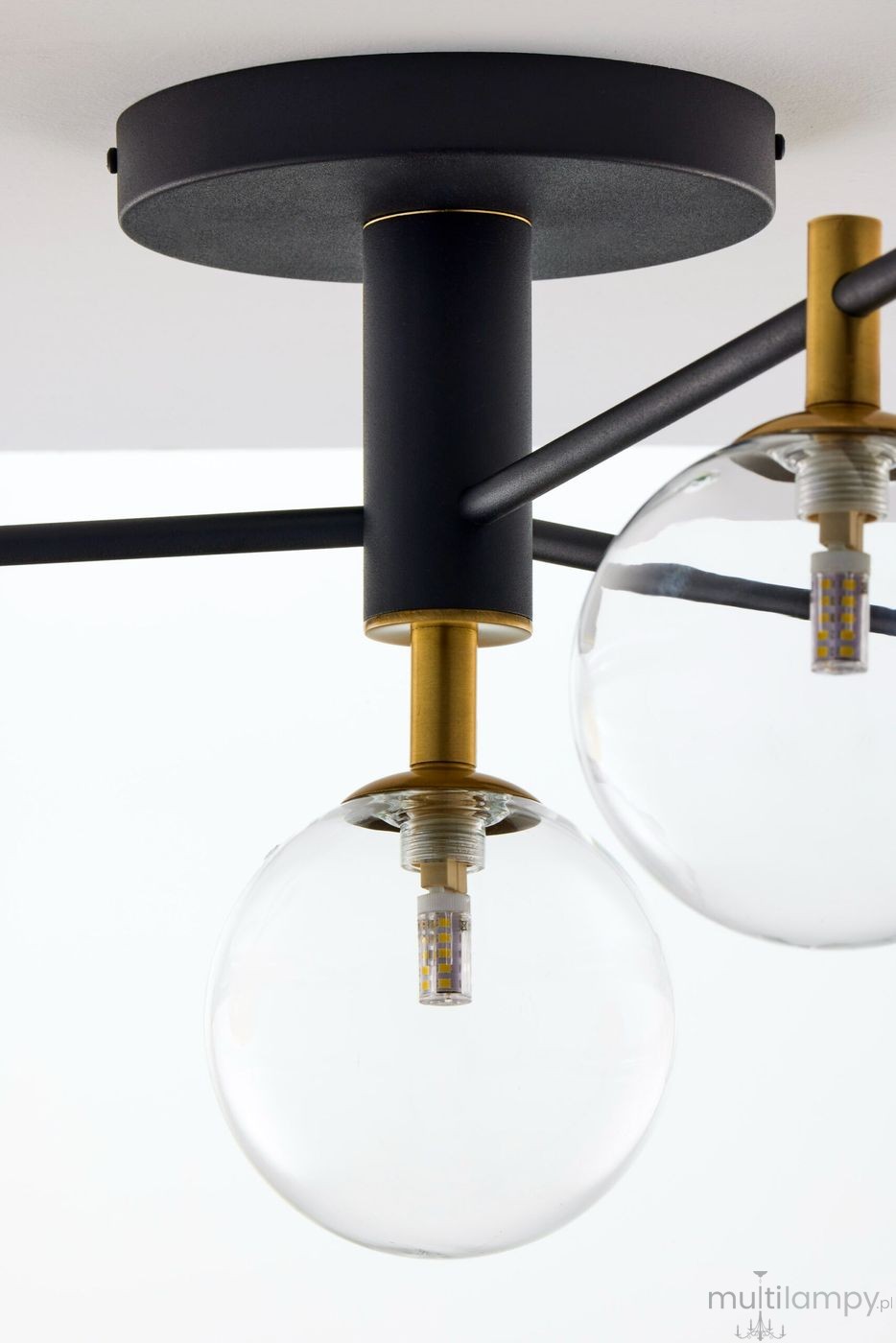 Lampa sufitowa Figaro 4xG9 w kolorze czarnym z transparentnymi kloszami. Metalowa konstrukcja z elementami w kolorze złotym. Widok z bliska na mocowanie i żarówki, podkreślający nowoczesny design i materiał wykonania.
