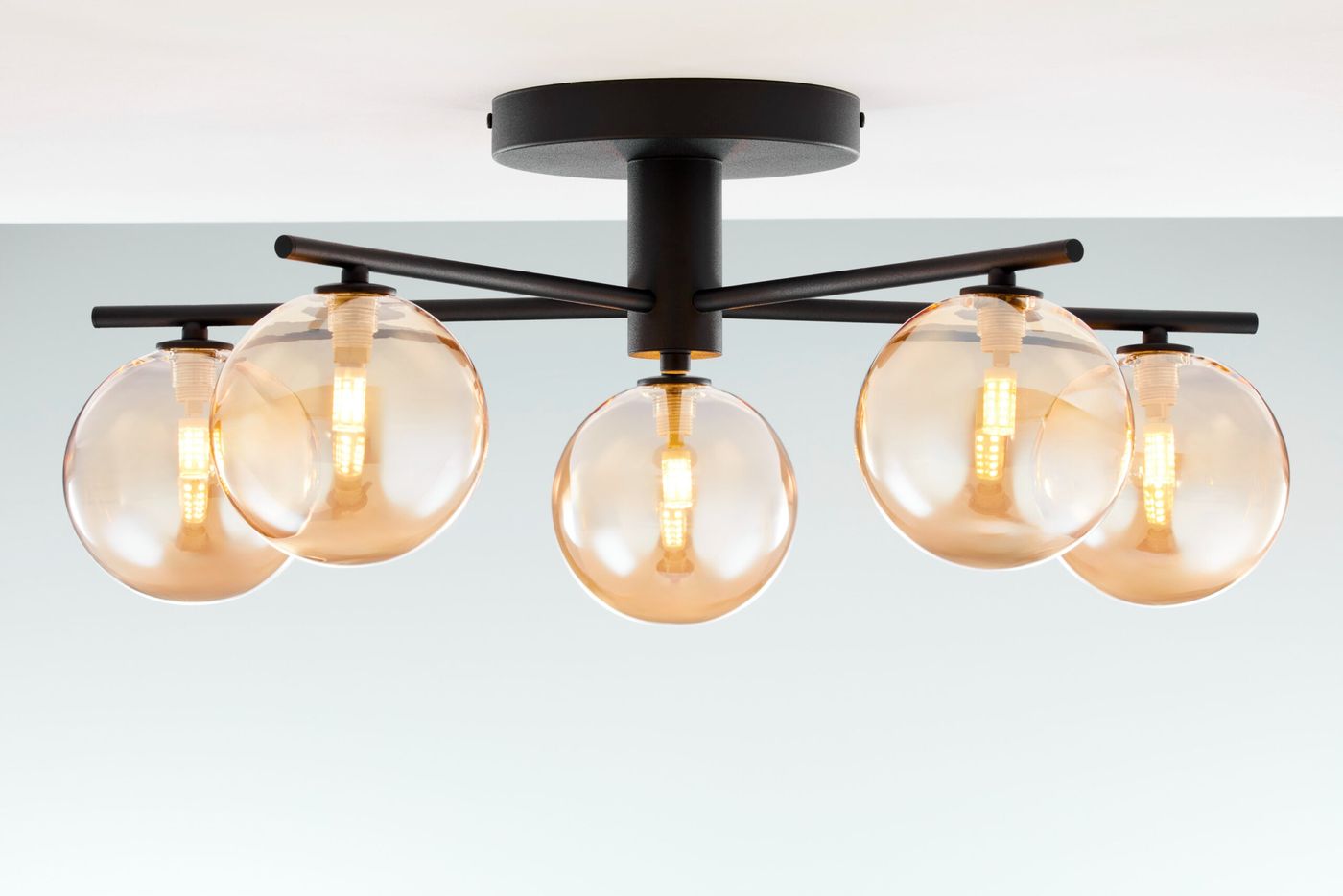 Lampa sufitowa Prato 5xG9 w kolorze czarnym z bursztynowymi kloszami. Posiada pięć okrągłych, przezroczystych kloszy, umieszczonych na czarnych ramionach. Montowana na suficie, zapewnia nowoczesne oświetlenie.