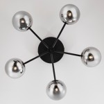 Lampa sufitowa Prato z pięcioma punktami świetlnymi G9, z czarnym metalowym stelażem i lustrzanymi, okrągłymi kloszami. Klosze umieszczone na ramionach w kształcie gwiazdy, widok z dołu.