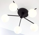 Lampa sufitowa Prato w kolorze czarnym, z pięcioma białymi okrągłymi kloszami, zamontowana na okrągłej podstawie. Klosze rozmieszczone na cienkich ramionach, widok z dołu, podkreślający nowoczesny design.