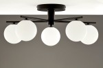 Lampa sufitowa Prato w kolorze czarnym z pięcioma białymi kulami G9. Ujęcie z dołu, pokazujące konstrukcję i kształt kloszy. Metalowy stelaż z czarnym wykończeniem, wisi pod sufitem na prostokątnej podstawie.