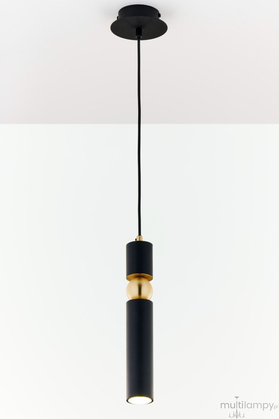 Lampa wisząca Alas w kolorze czarnym z metalową złotą dekoracją. Posiada pojedynczy gwint GU10. Ujęcie z dołu, wisząca na czarnym przewodzie, z cylindrycznym kształtem oraz minimalistycznym designem. Tło białe, proste.