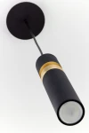 Lampa wisząca Alas w kolorze czarnym z metalowym detalem w kolorze złotym. Posiada miejsce na jedną żarówkę GU10, zawieszona na cienkim przewodzie z okrągłym mocowaniem sufitowym. Ujęcie z dołu, ukazujące kształt i detale lampy.