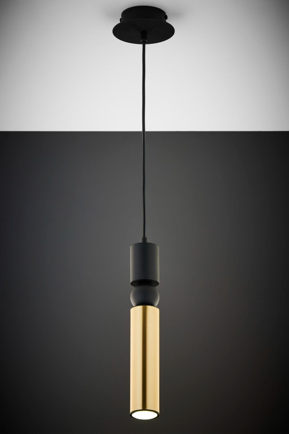 Lampa wisząca Alas z jednym źródłem światła GU10. Czarno-złota konstrukcja z cylindrycznym, błyszczącym kloszem. Wisi na czarnym przewodzie z okrągłym mocowaniem sufitowym. Prosta forma, idealna do nowoczesnych wnętrz.