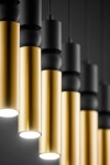Lampa wisząca Alas w kolorze czarnym i złotym, z sześcioma oprawami na żarówki GU10. Ujęcie zbliżeniowe, ukazujące metalowe cylindry w różnych odcieniach, z detalami wykończenia. Światło skierowane w dół, zawieszona na cienkich przewodach.
