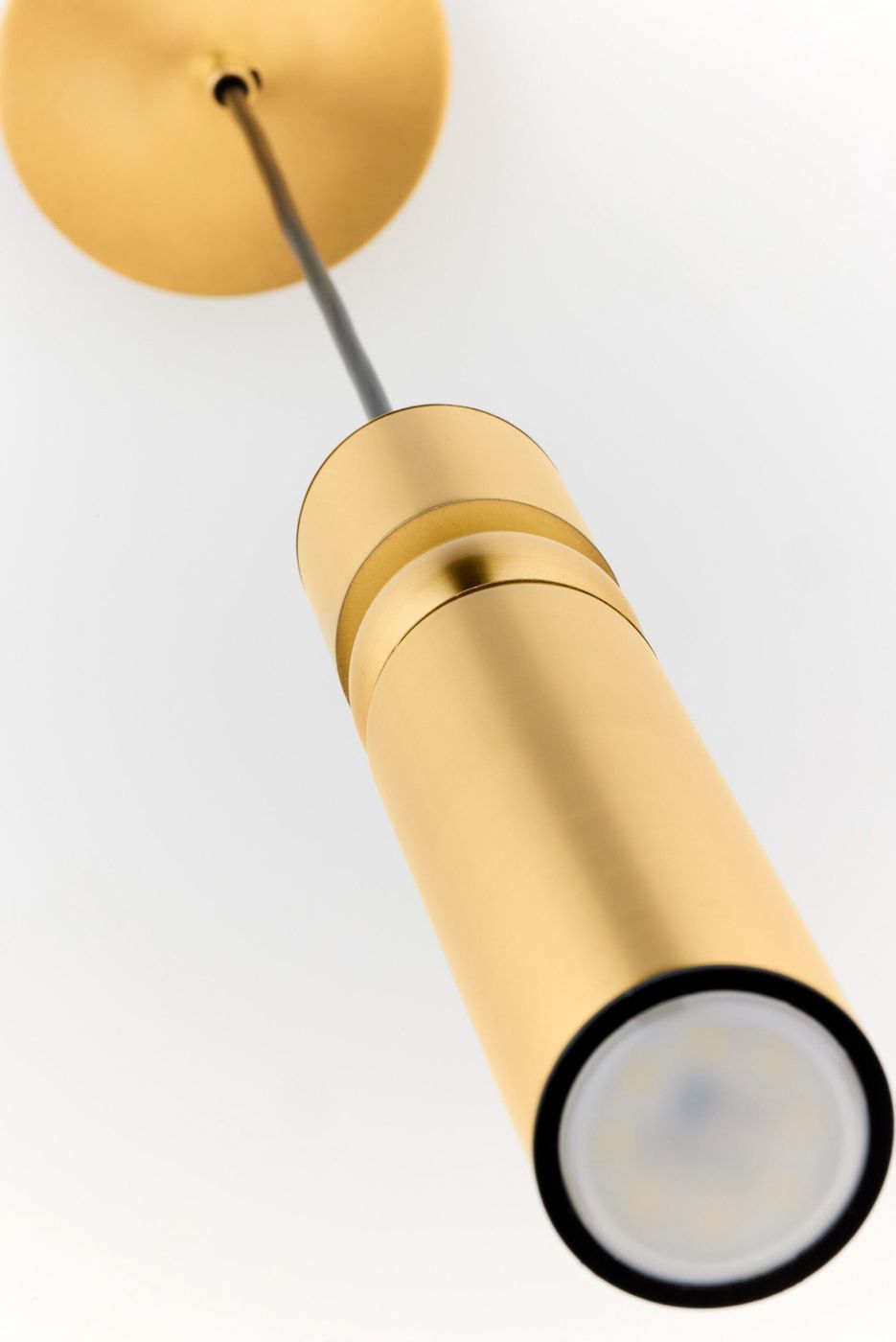 Lampa wisząca Alas w kolorze złotym, z oprawą na jedną żarówkę GU10. Ujęcie z dołu, ukazujące cylindryczny kształt i metaliczną fakturę. Wisi na cienkim przewodzie, zakończona okrągłym uchwytem montażowym. Tło białe, proste.