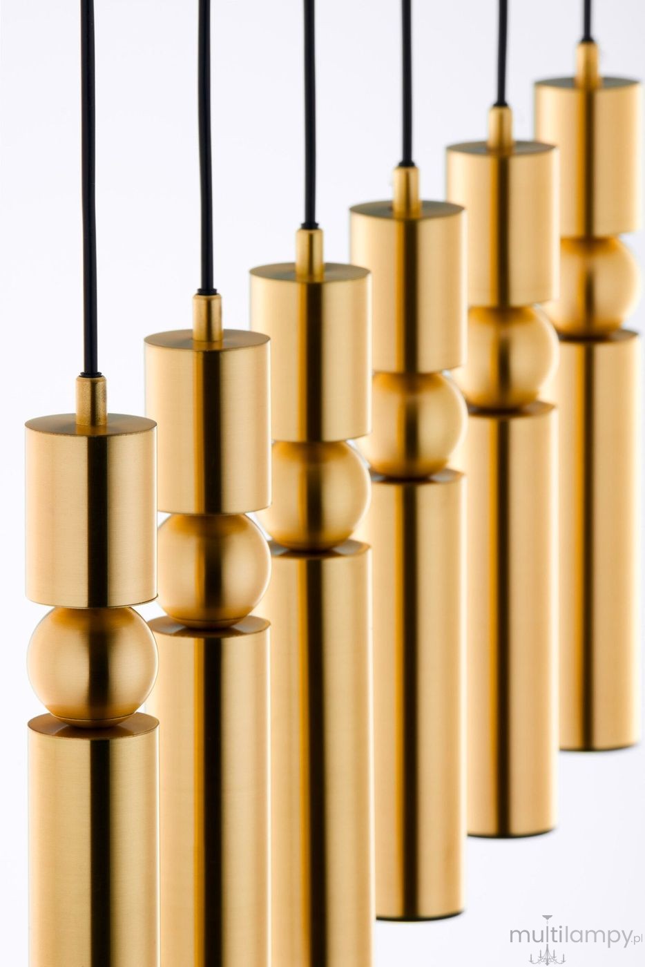 Lampa wisząca Alas w kolorze złotym, składająca się z sześciu cylindrycznych opraw, zawieszonych na czarnych przewodach. Elementy mają różne wysokości i kształty, w tym kuliste detale. Tło białe, co podkreśla elegancki design.