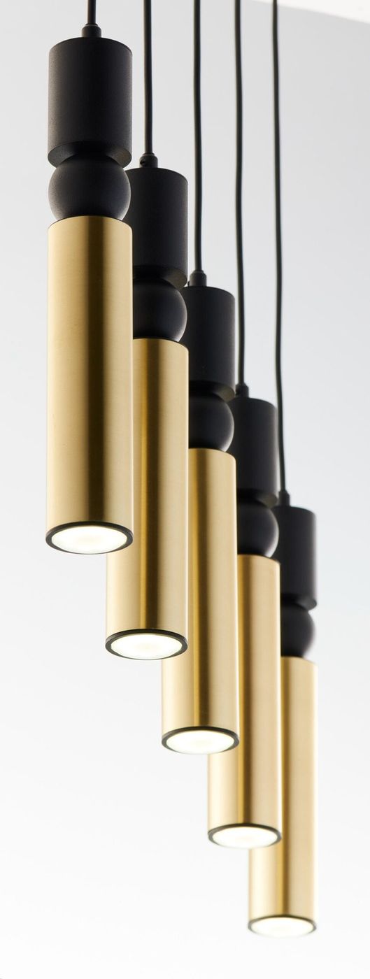 Lampa wisząca Alas z pięcioma źródłami światła GU10, w kolorze czarnym i złotym. Posiada cylindryczne klosze w złotym wykończeniu, umieszczone na czarnych podstawkach. Ujęcie z dołu, z widocznymi detalami konstrukcji i intensywnym światłem.