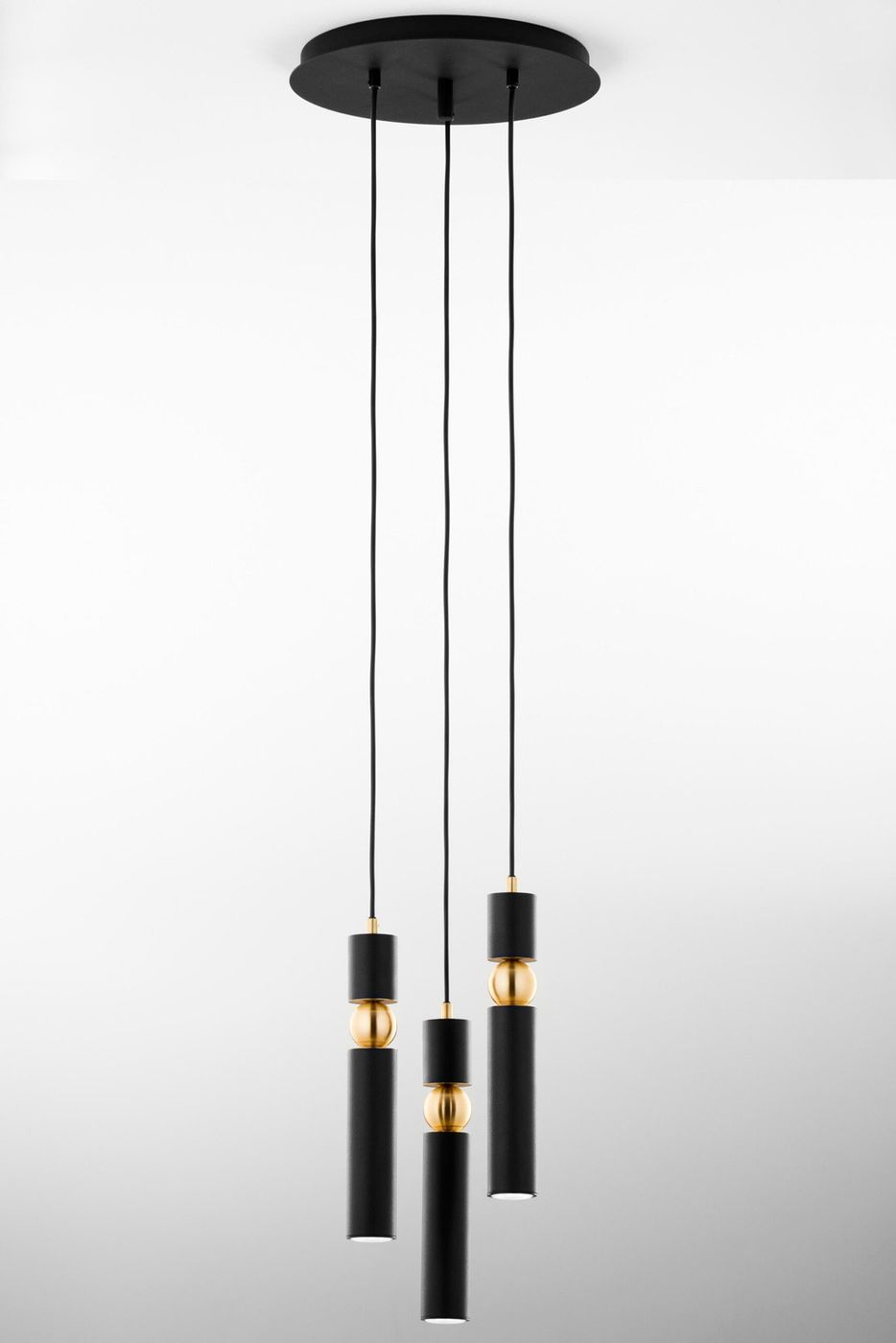 Lampa wisząca Alas w kolorze czarnym z trzema źródłami światła GU10. Posiada cylindryczne klosze z złotymi detalami, zawieszone na czarnych przewodach. Montaż sufitowy, nowoczesny design, idealna do aranżacji wnętrz.