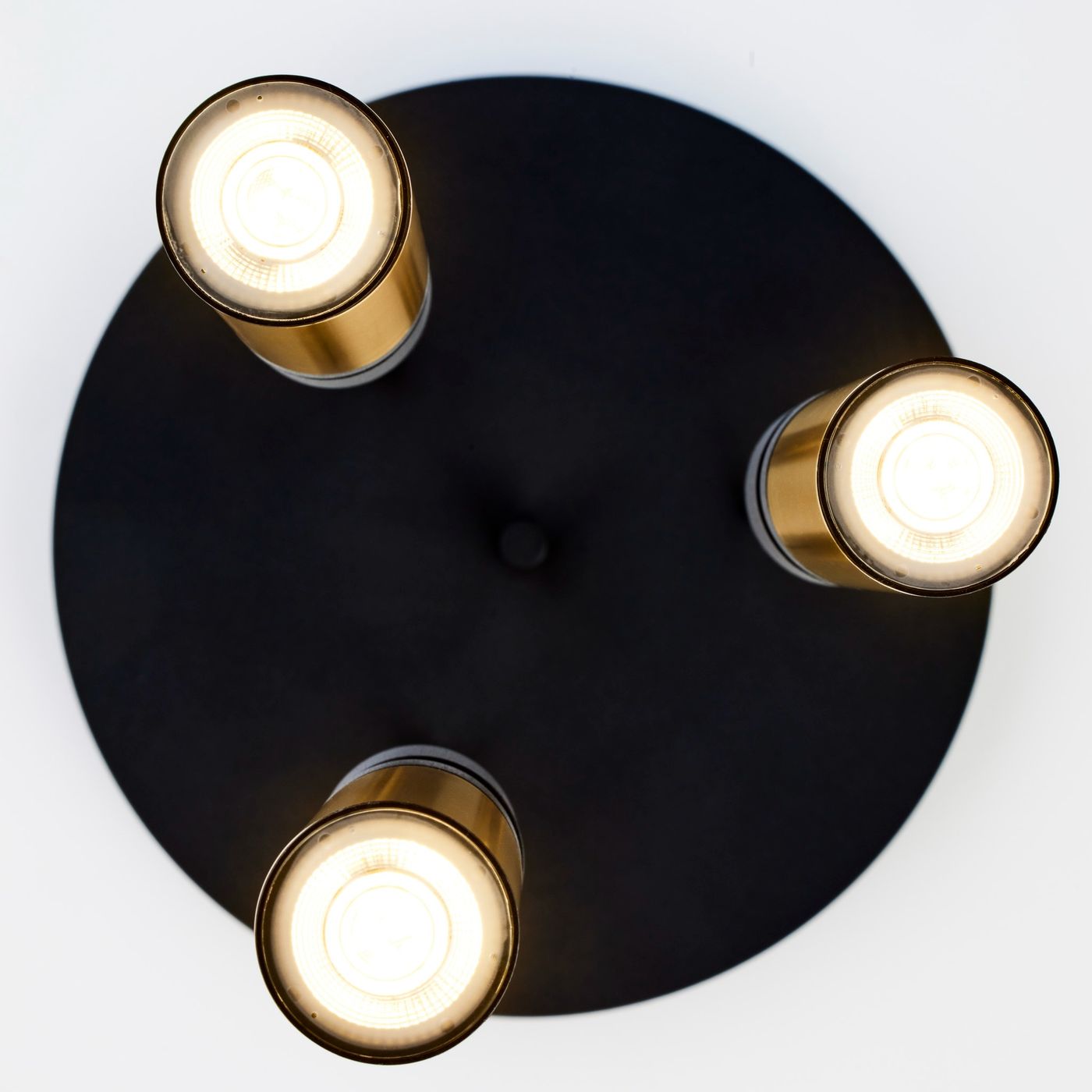 Lampa wisząca Alas z trzema oprawami GU10, czarna podstawa z metalową złotą dekoracją. Ujęcie z góry, ukazujące wszystkie trzy źródła światła i centralny guzik mocujący. Idealna do nowoczesnych wnętrz.
