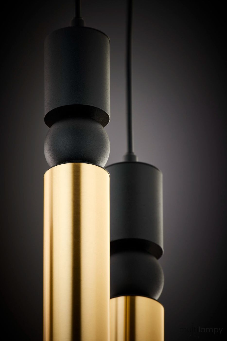 Lampa wisząca Alas w kolorze czarnym i złotym, z pięcioma oprawami GU10. Wyróżnia się cylindrycznymi elementami w złotym wykończeniu oraz czarnymi akcentami. Ujęcie z bliska, ukazujące detale konstrukcji i teksturę materiałów.