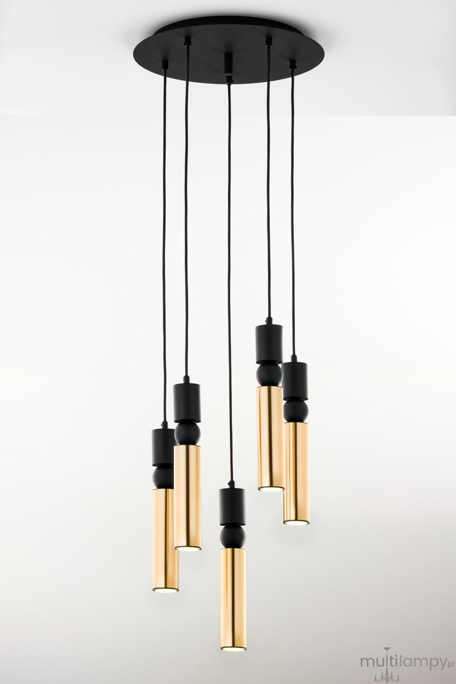 Lampa wisząca Alas z pięcioma źródłami światła GU10. Składa się z długich, cylindrycznych kloszy w kolorze złotym, zawieszonych na czarnych linkach. U góry znajduje się okrągła, czarna podsufitka. Całość ma nowoczesny design.