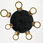 Lampa wisząca Alas z siedmioma oprawami GU10, z czarnym, okrągłym stelażem i złotymi kloszami. Ujęcie z dołu, ukazujące promieniujące światło. Klosze mają metaliczne wykończenie, a całość zawieszona na cienkich prętach.