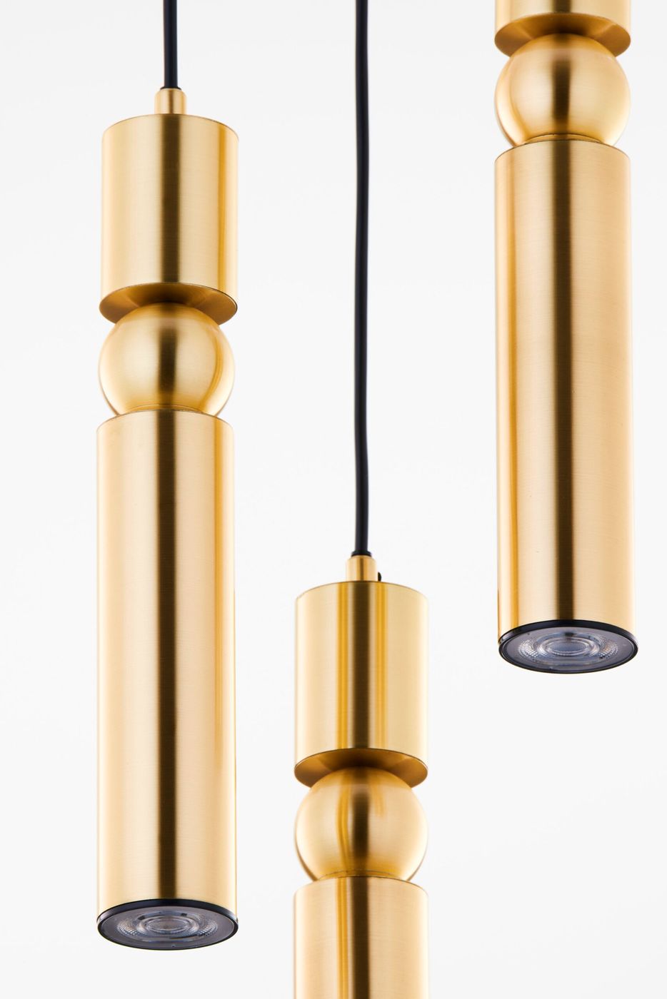 Lampa wisząca Alas w kolorze złotym z trzema źródłami światła GU10. Składa się z cylindrycznych elementów o różnych wysokościach, z widocznymi żarówkami na dole. Zawieszona na czarnym przewodzie, prezentuje nowoczesny design.