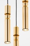 Lampa wisząca Alas w kolorze złotym, składająca się z trzech cylindrycznych elementów o różnej długości, z czarnym przewodem. W górnej części widoczne są okrągłe detale. Całość ma nowoczesny, minimalistyczny design.