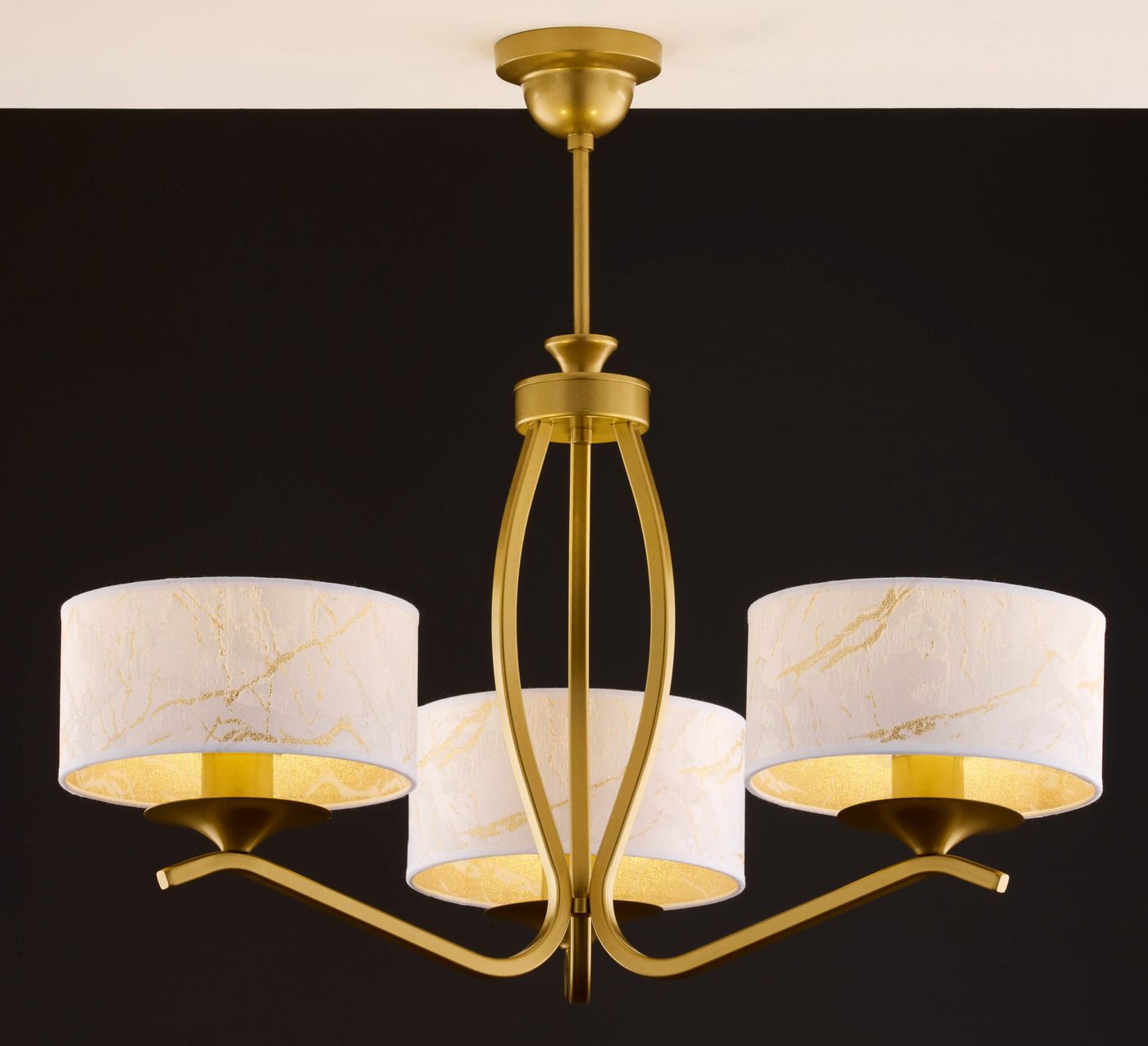 Kaszmir żyrandol 3xE27 w złotym kolorze, z trzema białymi kloszami ozdobionymi złotymi akcentami. Ujęcie frontalne, wiszący, z elegancką konstrukcją metalową. Tło ciemne, podkreślające detal i styl lampy.