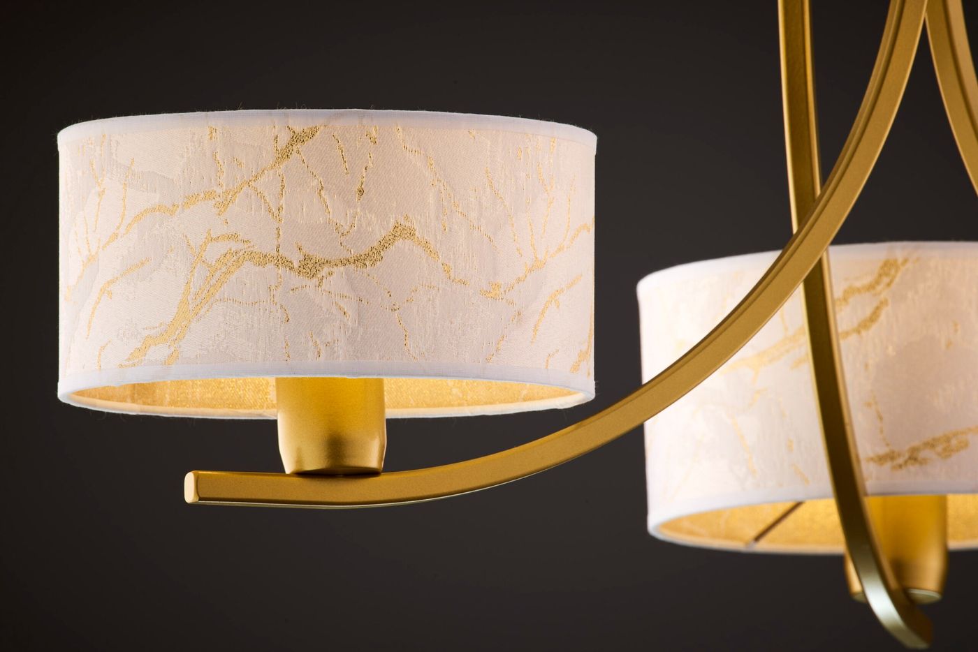 Żyrandol Arthur z trzema kloszami E27 w kolorze złotym i białym. Klosze z tekstury przypominającej marmur, z delikatnym złotym wzorem. Całość zawieszona na eleganckiej, złotej konstrukcji. Widok z boku, ukazujący detale kloszy i mocowania.