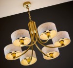 Żyrandol Arthur z sześcioma ramionami, w kolorze złotym z białymi kloszami o teksturowanej powierzchni. Umieszczony w dół, z widocznymi żarówkami E27. Klosze mają zaokrąglony kształt, a całość wisi na złotej łańcuchowej konstrukcji.