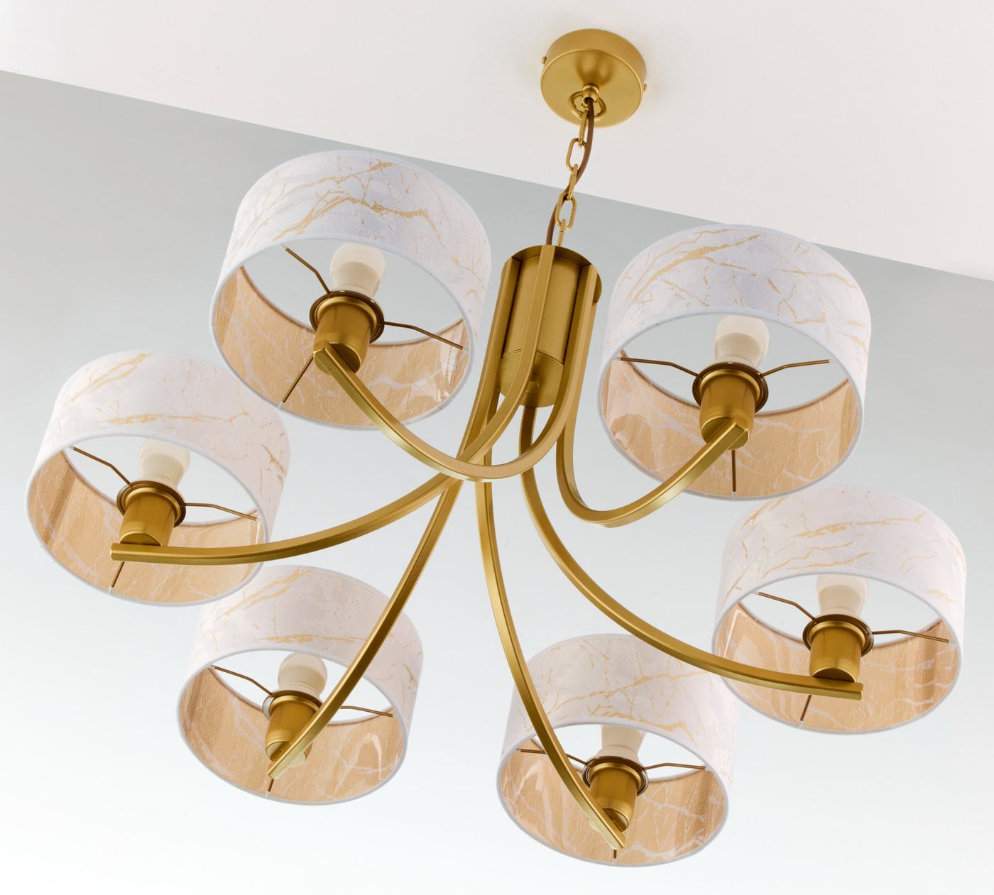 Żyrandol Arthur w kolorze złotym z sześcioma kloszami E27, wykonany z metalu i materiału. Klosze mają biały kolor z marmurkowym wzorem w odcieniach beżu. Produkt zamontowany na suficie, widoczny z dołu.