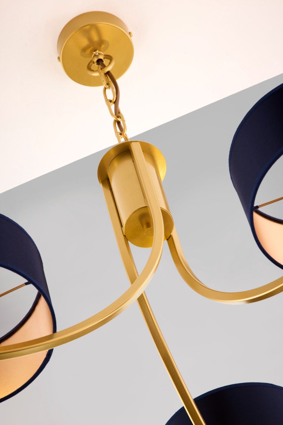 Żyrandol Arthur z trzema oprawami E27, w kolorze złotym z granatowymi kloszami. Widok z góry na elementy mocujące i zaokrąglone ramiona. Klosze mają wnętrze w jasnym odcieniu, co podkreśla elegancję lampy.
