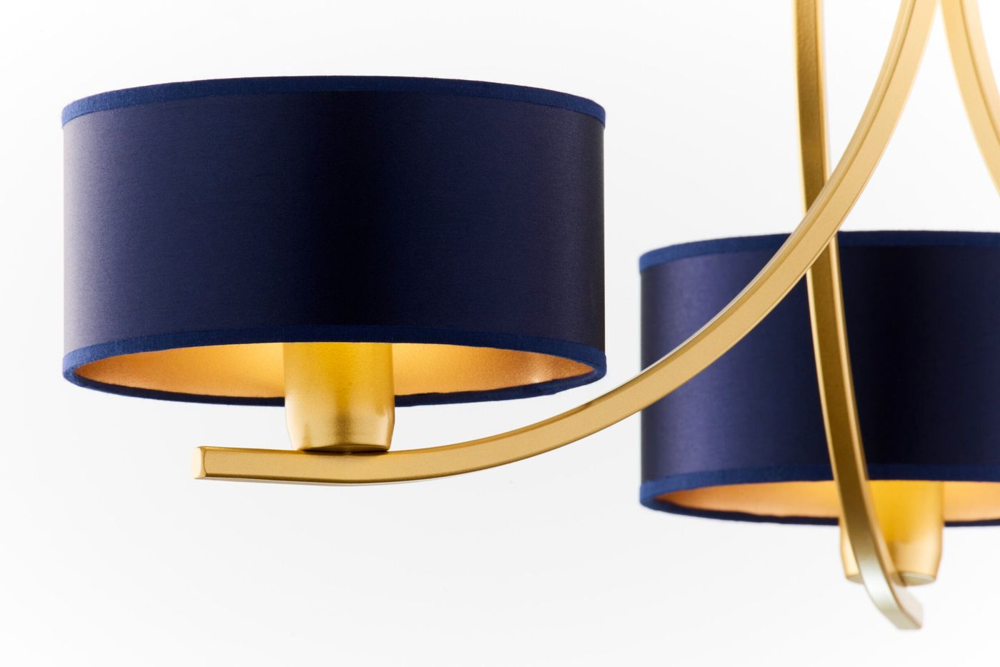 Żyrandol Arthur z trzema oprawami E27 w kolorze złotym i granatowym. Abazury w granatowym materiale z złotym wnętrzem, zawieszone na złotej konstrukcji, widok z boku, ukazujący detal i kształt lampy.