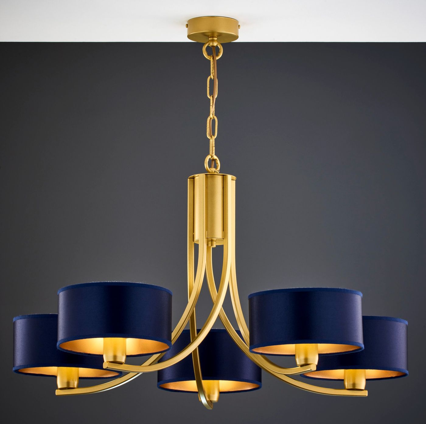 Żyrandol Arthur z pięcioma kloszami E27 w kolorze granatowym, z metalową, złotą konstrukcją. Klasyczny design z eleganckimi, okrągłymi kloszami, zawieszony na złotym łańcuchu. Idealny do nowoczesnych wnętrz.