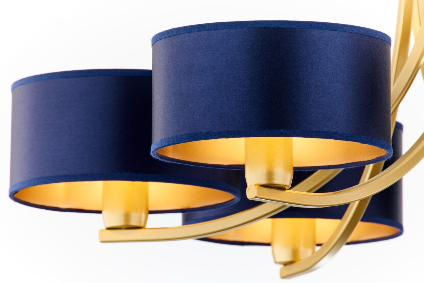 Żyrandol Arthur z sześcioma oprawami E27, w kolorze złotym i granatowym. Okrągłe klosze z granatowego materiału z wewnętrzną złotą powłoką, zamontowane na złotej konstrukcji. Ujęcie z przodu, ukazujące detale kloszy i mocowania.