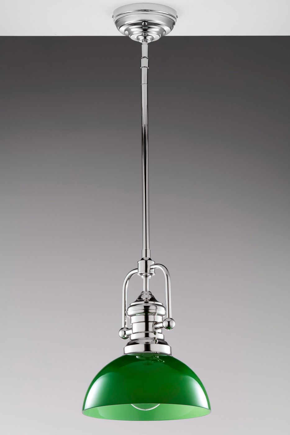 Lampa wisząca Platino w kolorze zielonym, wykonana z metalu i szkła. Ma okrągły klosz z lśniącym wykończeniem, zawieszona na długim, niklowym stelażu. Ujęcie z dołu pokazuje detal mocowania oraz źródło światła E27. Tło w odcieniach szarości.