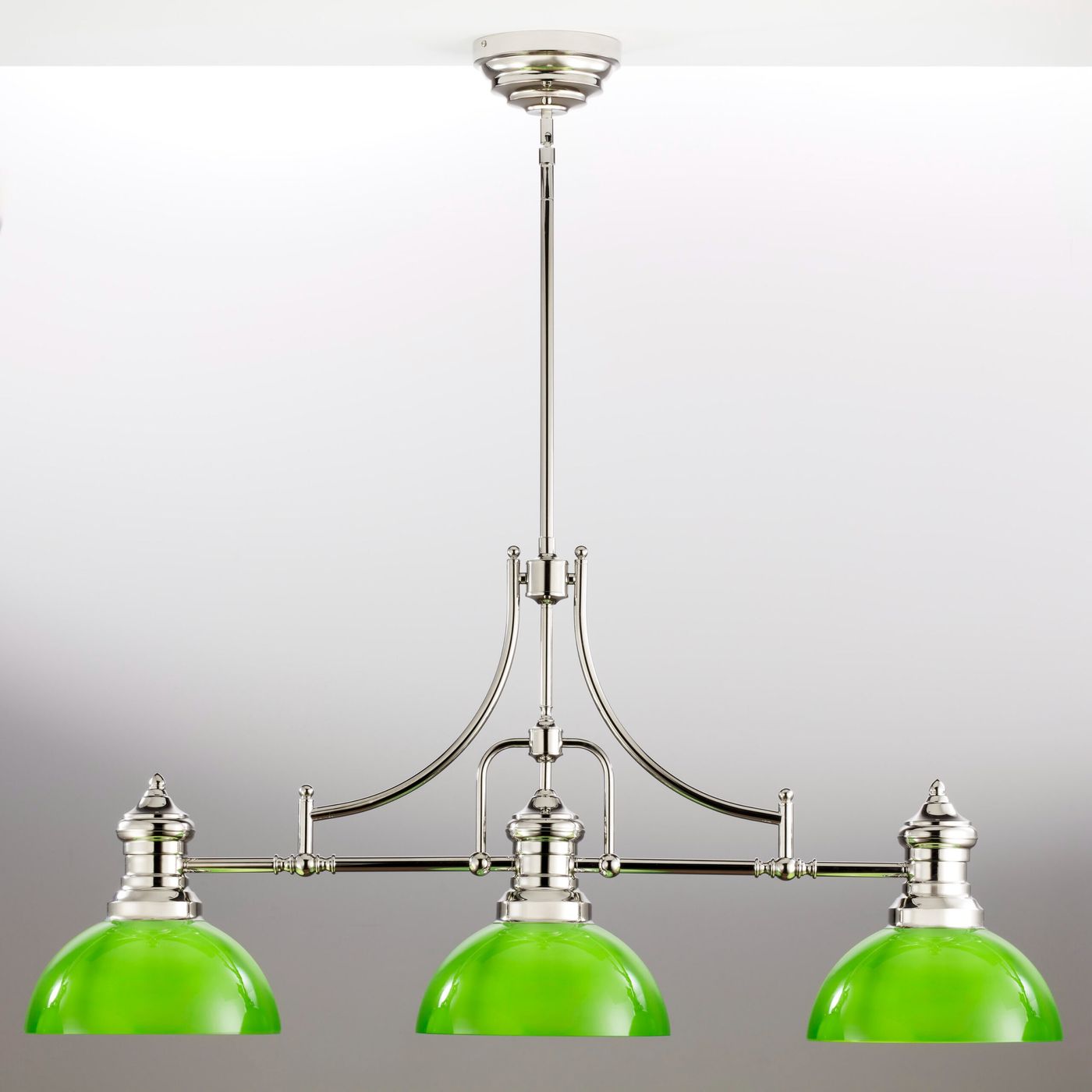 Lampa wisząca Platino w kolorze niklu z trzema zielonymi kloszami. Ujęcie frontalne, zawieszona na długim przewodzie. Klosze mają kształt półkulisty, metalowe detale wykończone są na wysoki połysk. Idealna do nowoczesnych wnętrz.