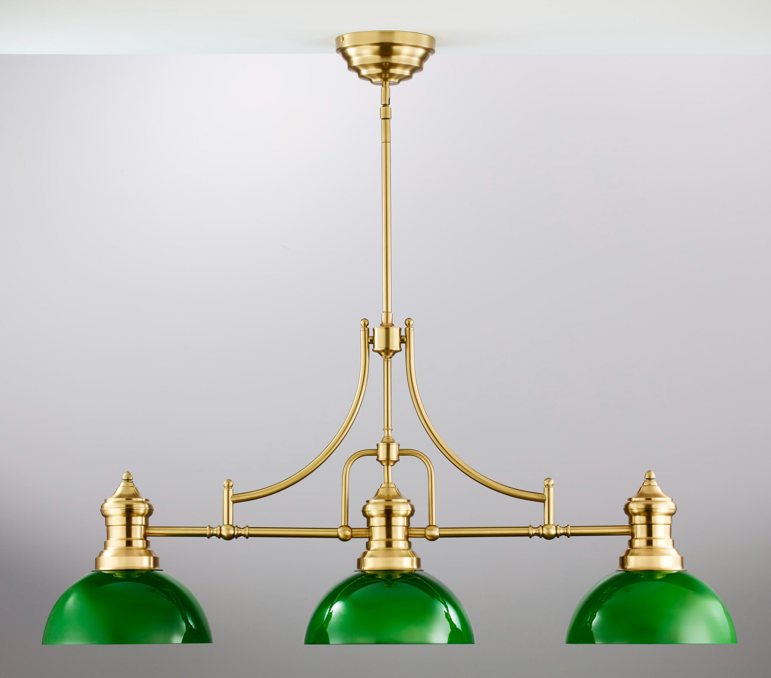 Lampa wisząca Platino z mosiądzu szczotkowanego, z trzema zielonymi kloszami. Ujęcie frontalne, produkt zwisający z sufitu, z eleganckimi zdobieniami i prostą, wyważoną formą. Idealna do nowoczesnych wnętrz.