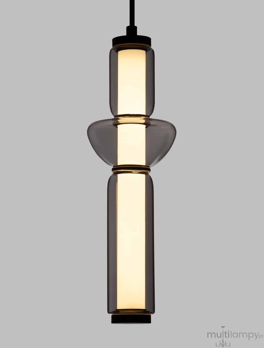 Lampa wisząca Glorica w kolorze czarnym, z jednolitą konstrukcją z przezroczystego szkła. Składa się z cylindrycznego korpusu oraz zaokrąglonej podstawy. Zawiera źródło światła LED 13W, umieszczone w centralnej części, zawieszona na czarnym przewodzie.