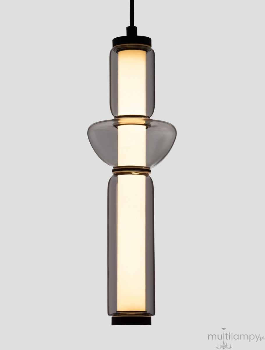 Lampa wisząca Glorica 1xLED 15W w kolorze czarnym, z przezroczystymi elementami szklanymi. Ma cylindryczny kształt z dwoma dużymi kloszami oraz centralnym źródłem światła, zawieszona na cienkim kabelku. Tło jednolite, szare.