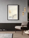 Lampa wisząca Rebalvo 1xLED 7W w kolorze złotym, o prostym cylindrycznym kształcie, zawieszona na cienkim przewodzie. Widoczna w nowoczesnym wnętrzu z szaro-beżowymi tonami, obok abstrakcyjnego obrazu i stylowego fotela.
