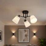 Lampa sufitowa Pafos z trzema kloszami w kolorze czarnym, wykonana z metalu, z białymi, stożkowymi kloszami. Ujęcie z dołu, pokazujące lampę zamontowaną na suficie w nowoczesnym wnętrzu.