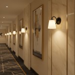 Kinkiet Pafos 1xE27 w kolorze czarnym z kloszem w kształcie stożka, zamontowany na ścianie w eleganckim korytarzu. W tle widoczne zdjęcia w złotych ramach oraz jasne oświetlenie, tworzące przytulną atmosferę.