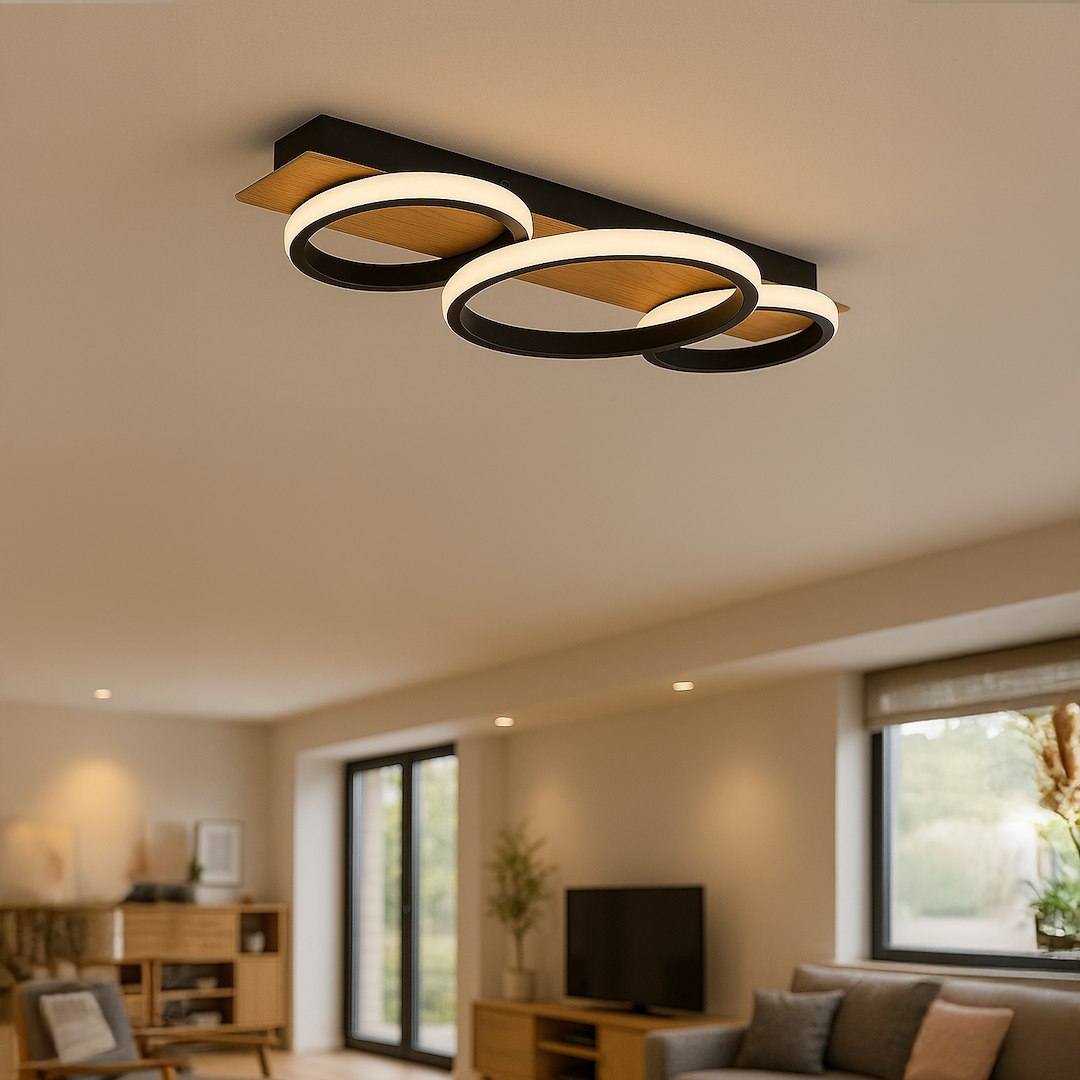 Czarna lampa sufitowa LED Rowena o mocy 18W i temperaturze barwowej 4000K, z trzema okrągłymi kloszami w formie pierścieni, zawieszona na drewnianym elemencie, umieszczona w nowoczesnym wnętrzu.