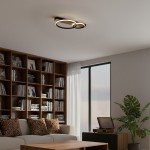 Czarna lampa sufitowa LED Rowena 14W 4000K z dwoma okrągłymi pierścieniami, zamontowana na suficie. Oświetlenie nowoczesne, w minimalistycznym stylu, idealne do wnętrz. Tło z regałem książek i rośliną w doniczce.