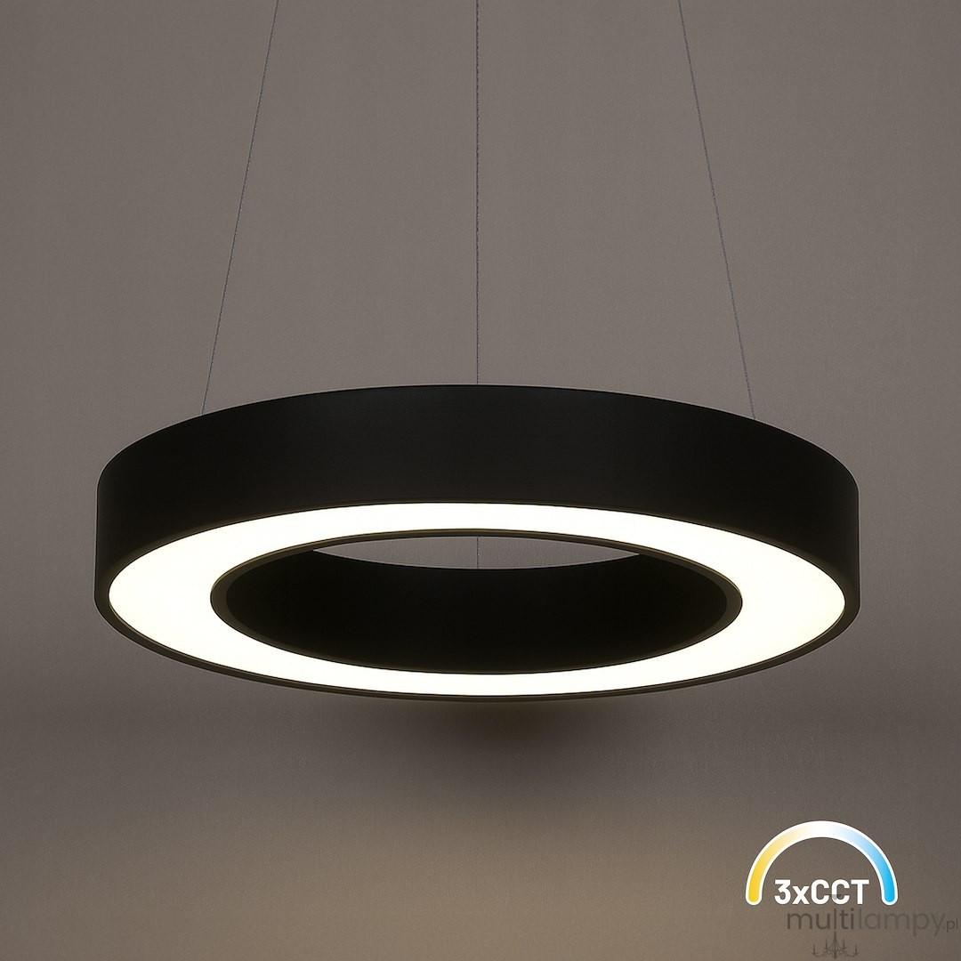 Lampa wisząca LED Union 40W CCT w kolorze czarnym, o okrągłym kształcie, z białym pierścieniem świetlnym. Zawieszona na cienkich linkach, prezentuje nowoczesny styl. Oświetlenie dostępne w trzech temperaturach barwowych. Tło w stonowanej kolorystyce.