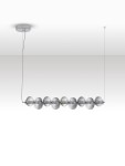 Lampa wisząca Tanvera z jednym źródłem LED 30W, w kolorze chromu i szarości. Posiada osiem szklanych, cylindrycznych kloszy z wyraźnym żłobieniem, zawieszona na cienkim kablu. Montowana do sufitu na okrągłej podstawie.