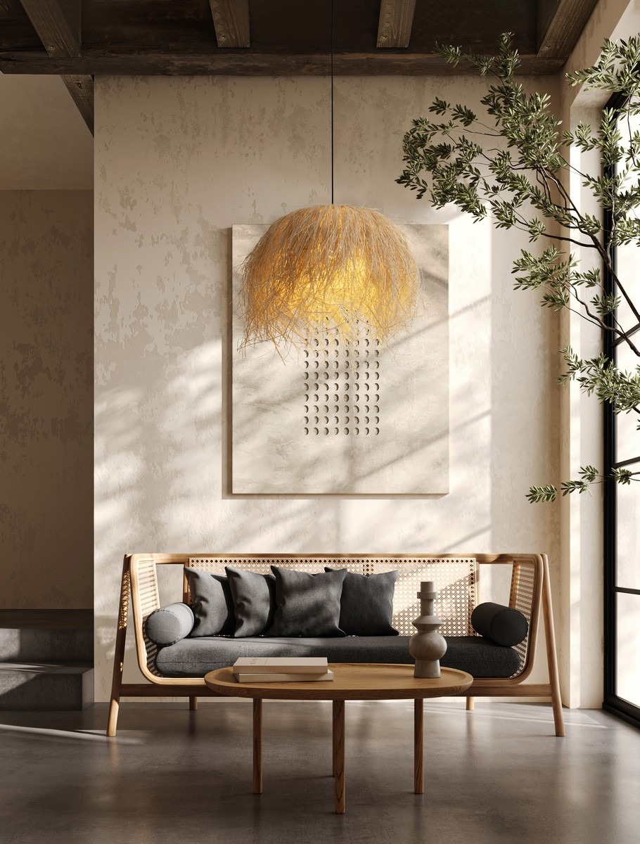 Lampa wisząca Ovincia 1xE27 w czarnym rattanowym wykończeniu, zawieszona nad stolikiem w nowoczesnym wnętrzu, z widocznymi detalami tekstury i kształtu klosza. Tło w neutralnych odcieniach, z elementami drewnianymi i roślinnymi.
