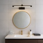 Vinci kinkiet L60 LED 15W 4000K IP44 w kolorze czarnym, zamontowany nad okrągłym lustrem z złotą ramą. Oświetlenie w minimalistycznym stylu, umieszczone na jednolitej, jasnej ścianie, w otoczeniu umywalki i akcesoriów łazienkowych.