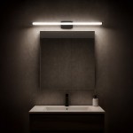 Mirore kinkiet L60 LED 10W 4000K IP44 w kolorze czarnym, zamontowany nad lustrem w łazience. Oświetlenie w formie prostokątnej listwy LED z minimalistycznym designem, emitujące neutralne światło, na tle ciemnej ściany.