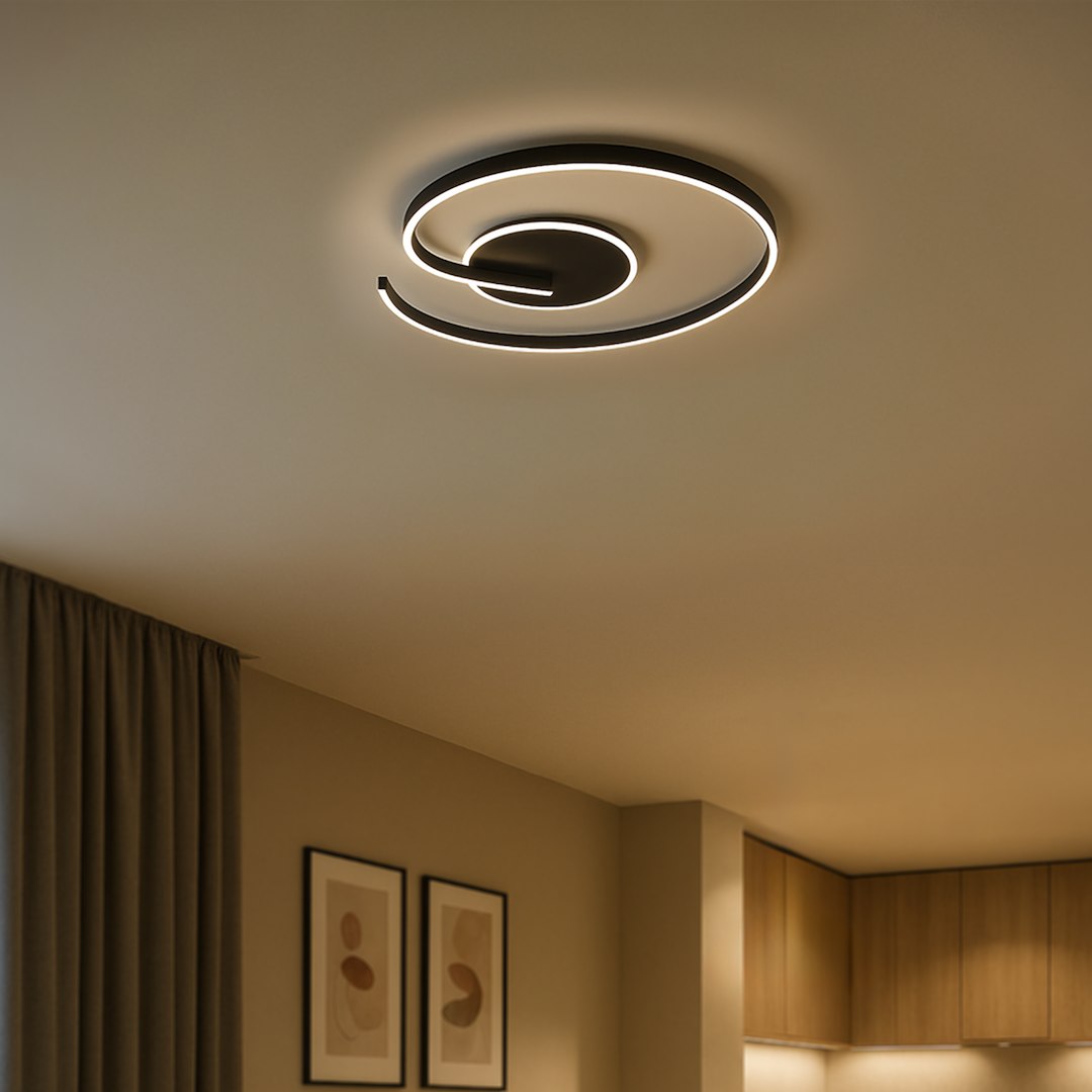 Lampa sufitowa LED Lorenzo 22W w kolorze czarnym, z unikalnym spiralnym kształtem. Oświetlenie w odcieniu 4000K, zamontowana na suficie w nowoczesnym wnętrzu, z widocznym tle ściany w neutralnych kolorach oraz zasłoną.