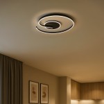 Lampa sufitowa LED Lorenzo 22W w kolorze czarnym, z unikalnym spiralnym kształtem. Oświetlenie w odcieniu 4000K, zamontowana na suficie w nowoczesnym wnętrzu, z widocznym tle ściany w neutralnych kolorach oraz zasłoną.