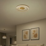 Lampa sufitowa LED Lorenzo 22W 4000K w kolorze złotym, o nowoczesnym, spiralnym kształcie, zamontowana na suficie. W tle widoczne abstrakcyjne obrazy w ramkach oraz jasna sofa, tworzące elegancką aranżację wnętrza.