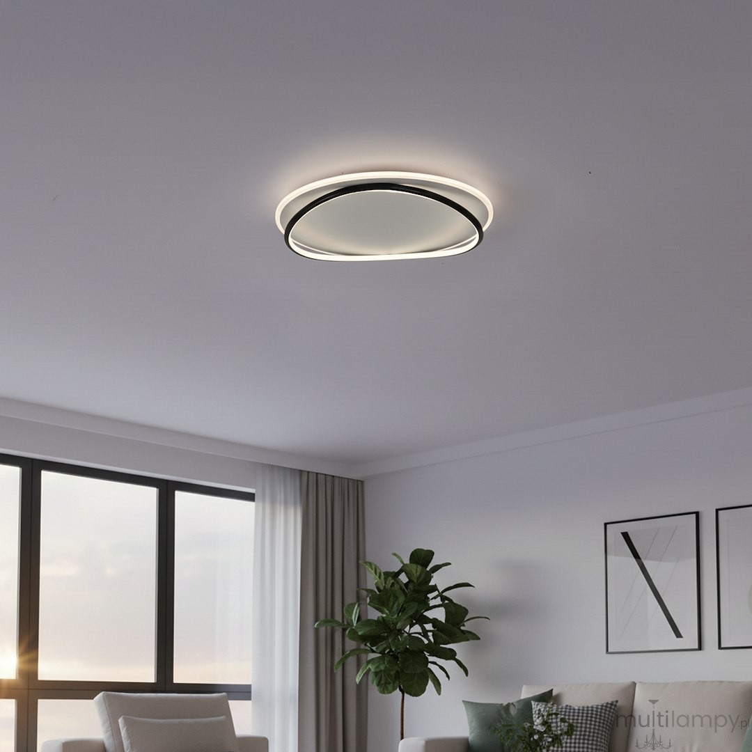 Lampa sufitowa LED Halo 38W, 4000K, w kolorze czarno-białym, o okrągłym kształcie. Zainstalowana na suficie, emituje jasne, neutralne światło. Tło to nowoczesne wnętrze z oknem, rośliną i sofą.