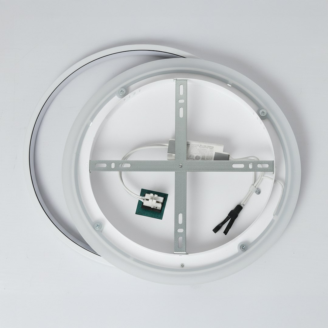 Biała lampa sufitowa LED Cordoba, o mocy 30W i temperaturze barwowej 4000K. Widok od spodu, z metalowym stelażem, przewodami oraz diodami. Okrągły kształt z cienką obwódką. Tło białe, ukazuje detale konstrukcji.